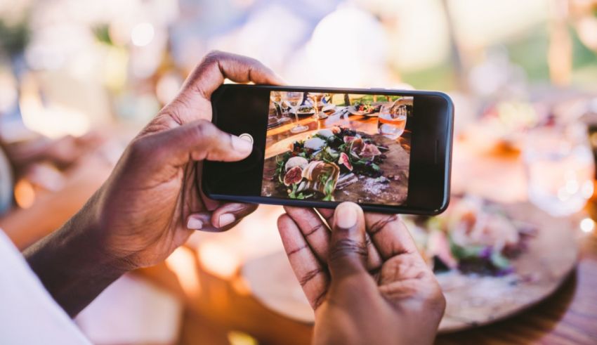A person taking a picture of food on a smartphone.