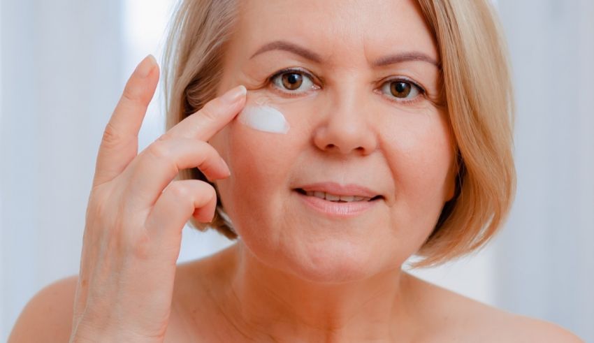 A woman applying a cream to her face.