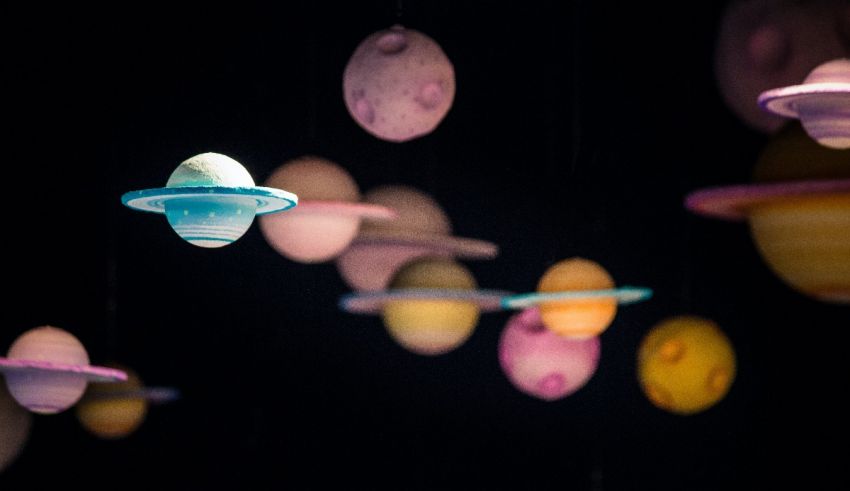 A group of colorful saturns hanging from the ceiling.