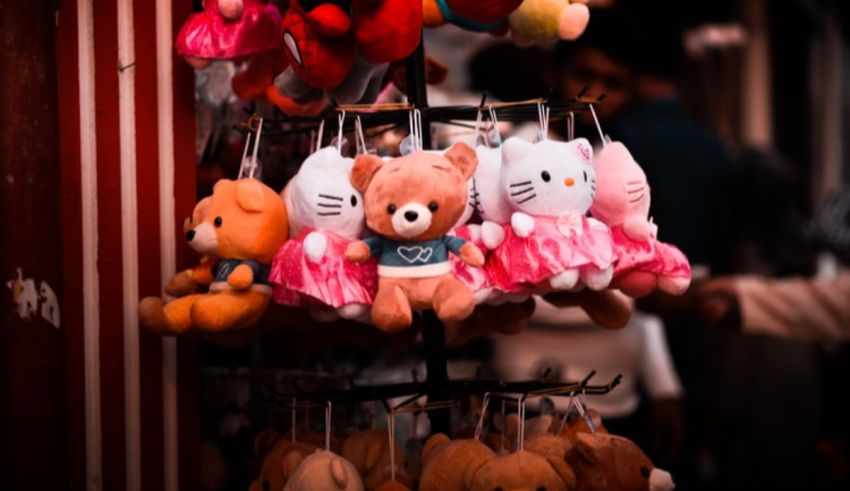 Teddy bears hanging on a rack in a market.
