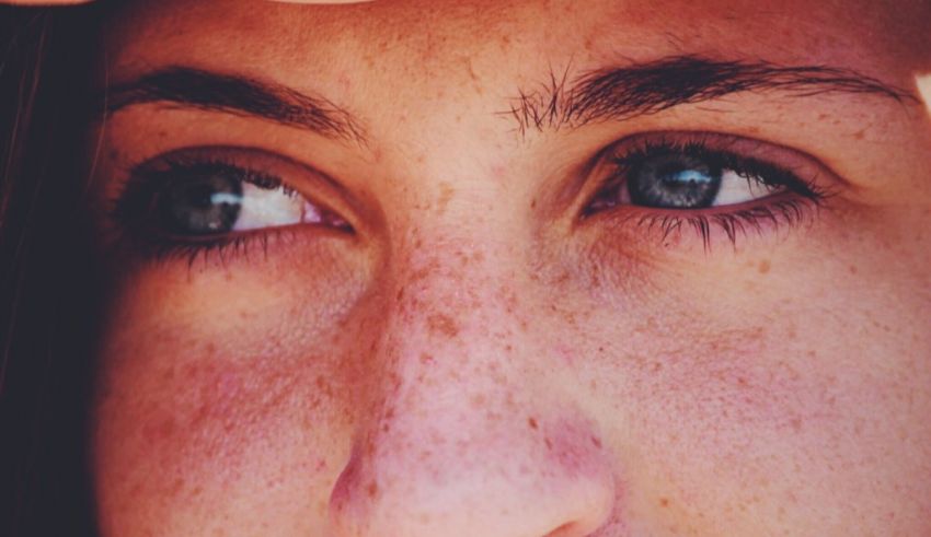 A close up of a woman's face with freckles.