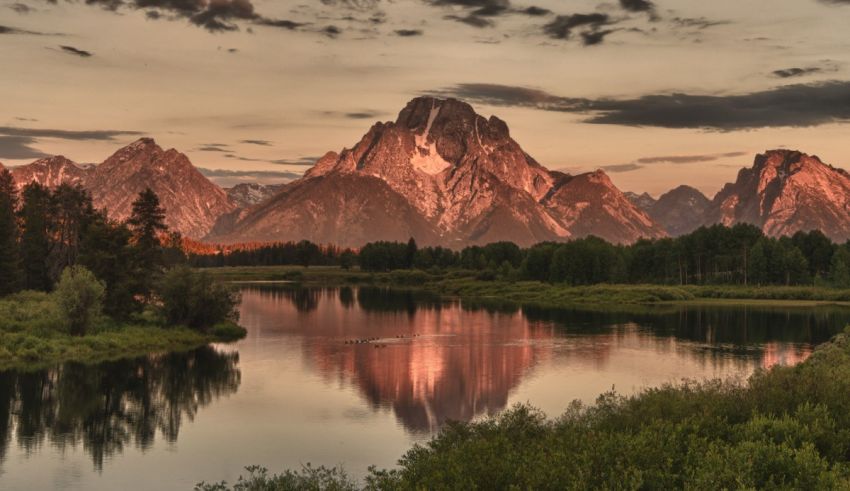 A lake with trees and mountains in the background.