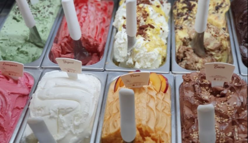 Many different flavors of ice cream in trays.