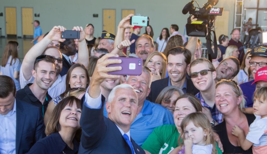 A group of people taking a selfie with a man in a suit.
