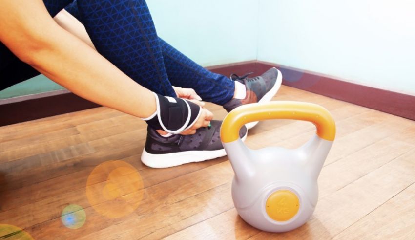 A woman is tying her shoe to a kettlebell.