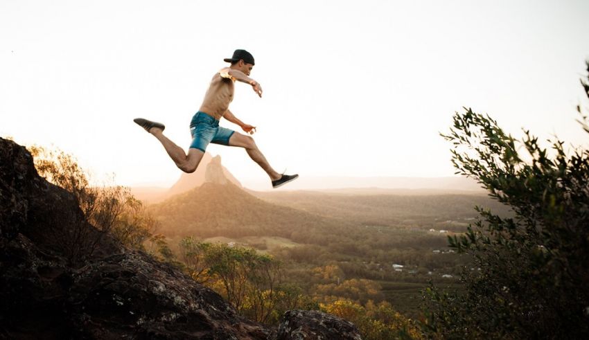 A man jumping in the air over a mountain.