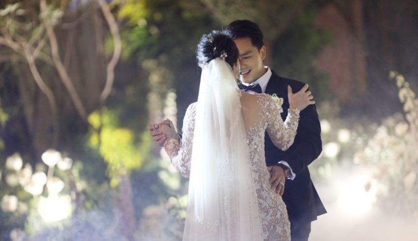 A bride and groom are dancing in front of a fog.