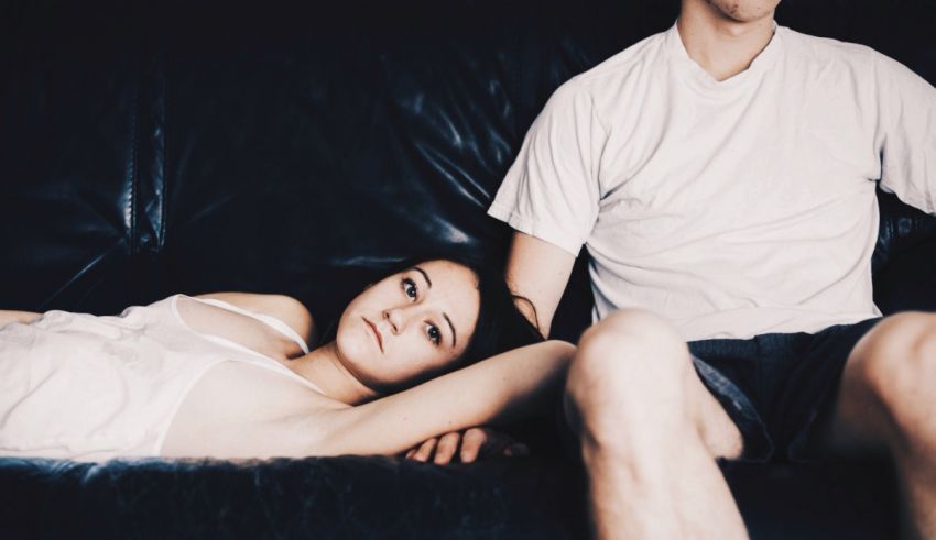 A man and woman laying on a couch.