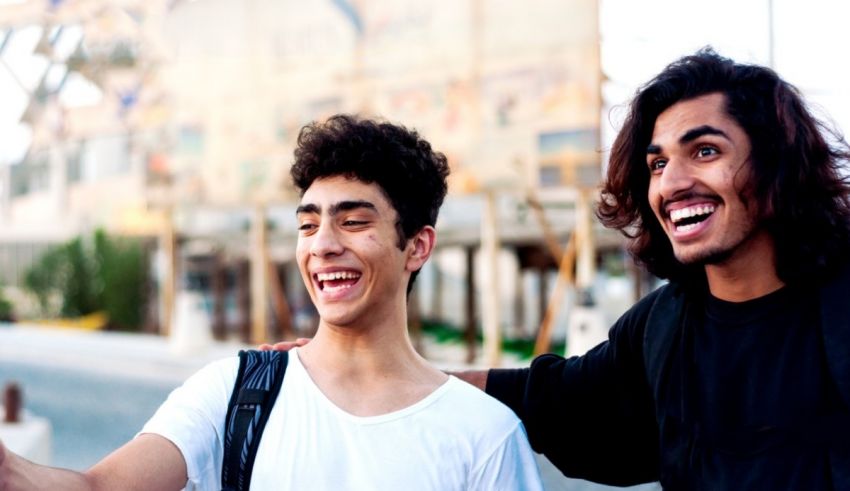 Two young men smiling while taking a selfie.