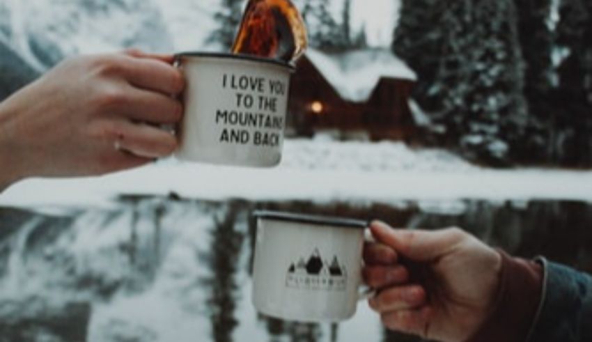 Two people holding mugs with the words i love to the mountains and lakes.