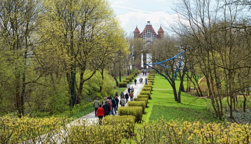 A group of people walking on a path with trees and bushes.