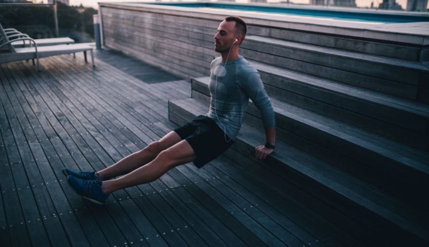 A man doing squats on the steps of a building.