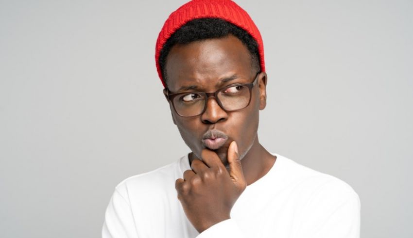 A black man wearing glasses and a red beanie.