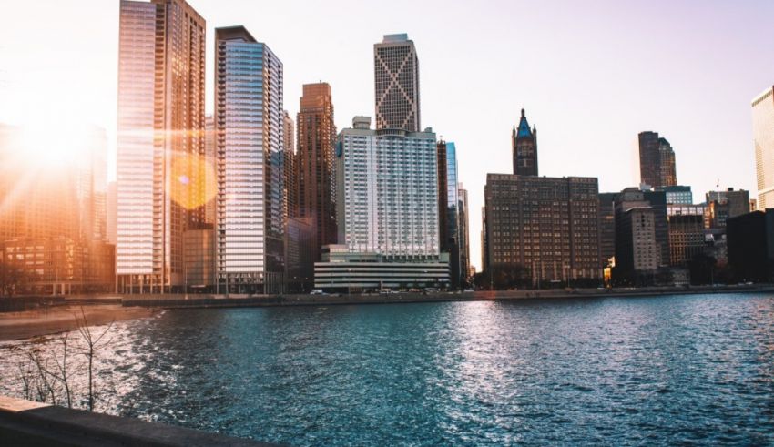 A city skyline with water and sun shining.