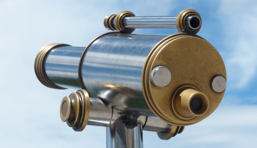 A telescope on top of a pole with a blue sky.