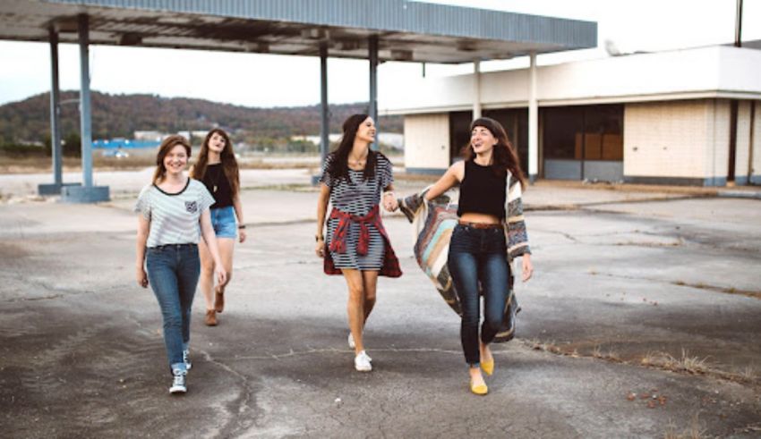 A group of girls walking in an empty parking lot.