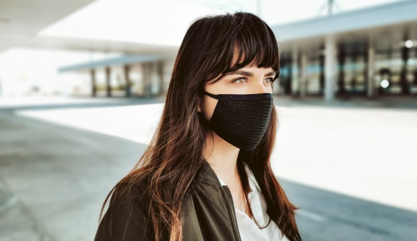 A woman wearing a face mask in an airport.