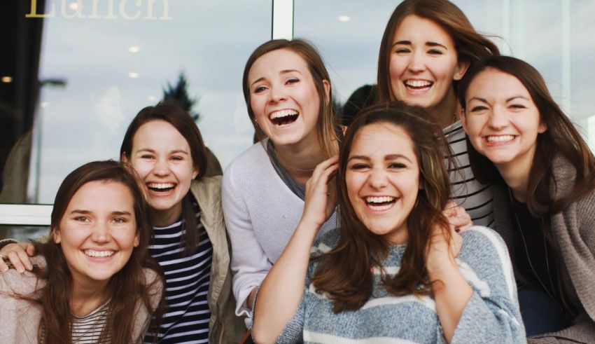 A group of women are smiling in front of a store.