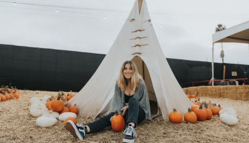 A woman sitting in front of a teepee.
