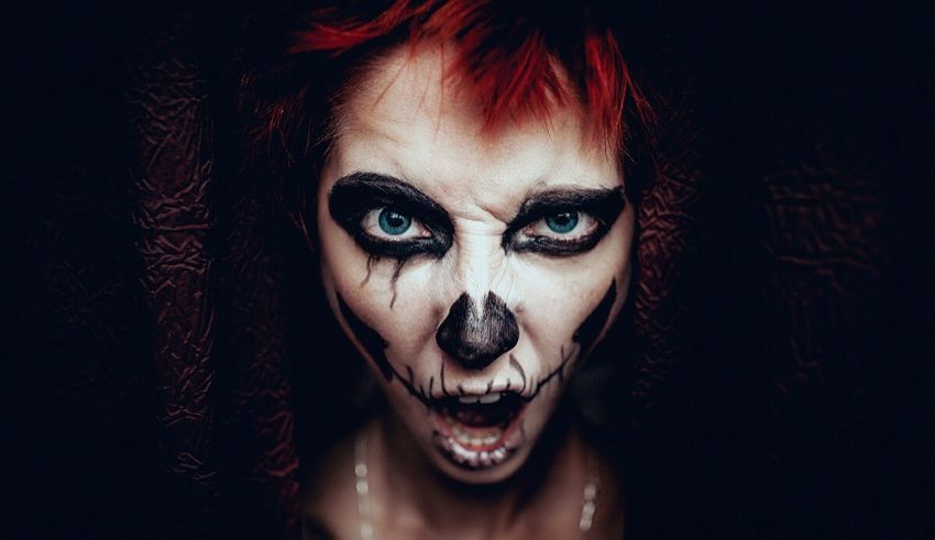 A woman with red hair and black face paint.