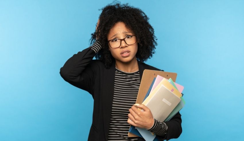 A woman holding a folder on her head while looking at a blue background.