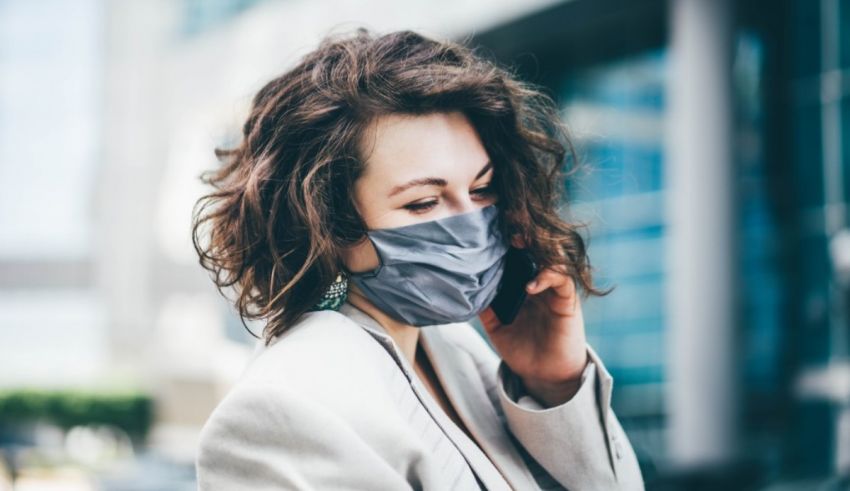 A woman wearing a surgical mask while talking on the phone.