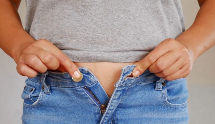 A woman is holding a coin in her jeans.
