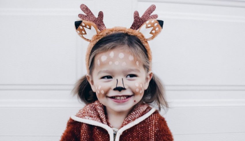 A girl with painted face and antlers.