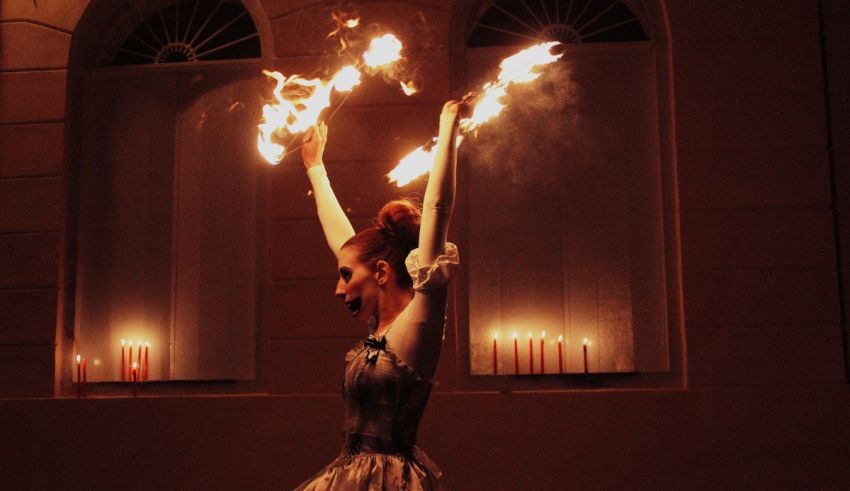 A woman in a dress with fire in her hands.