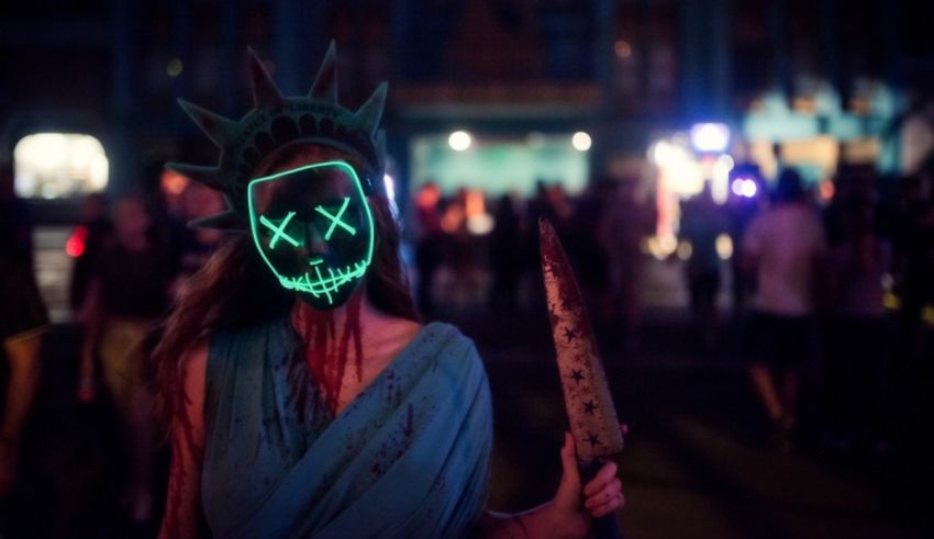 A woman wearing a mask holding a knife in front of the statue of liberty.