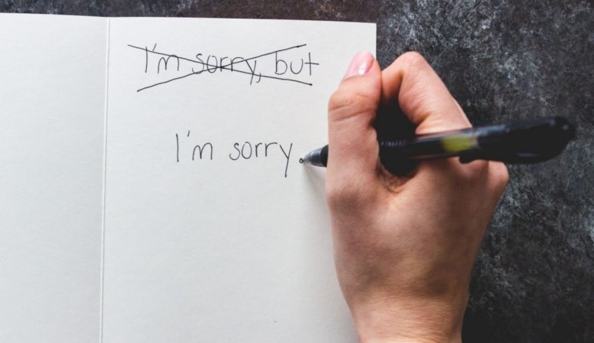 A person writing in a notebook with the words sorry but i'm sorry.