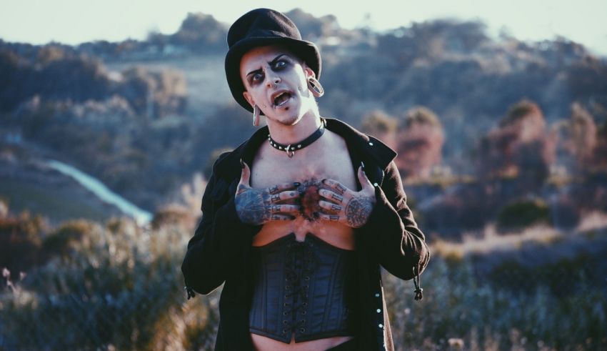 A man with tattoos on his face and a hat.