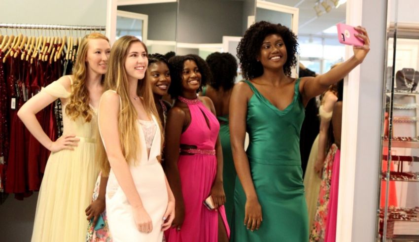 A group of girls taking a selfie in a dress shop.