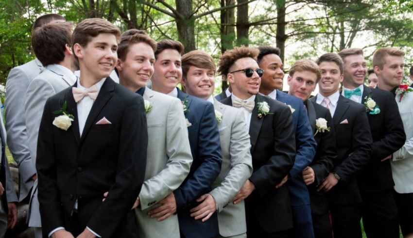 A group of young men in tuxedos posing for a photo.