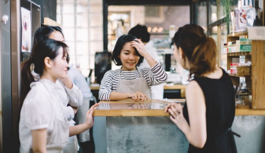 A group of women talking at a counter in a coffee shop.