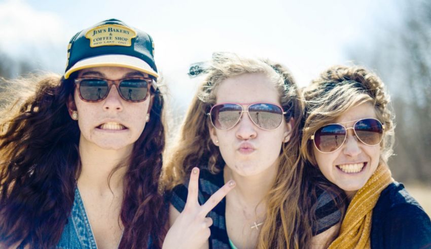 A group of women wearing sunglasses and making faces.