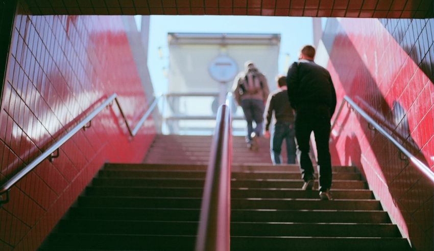 A group of people walking down stairs in a red building.