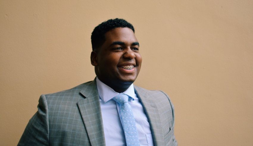 A black man in a suit and tie smiling.