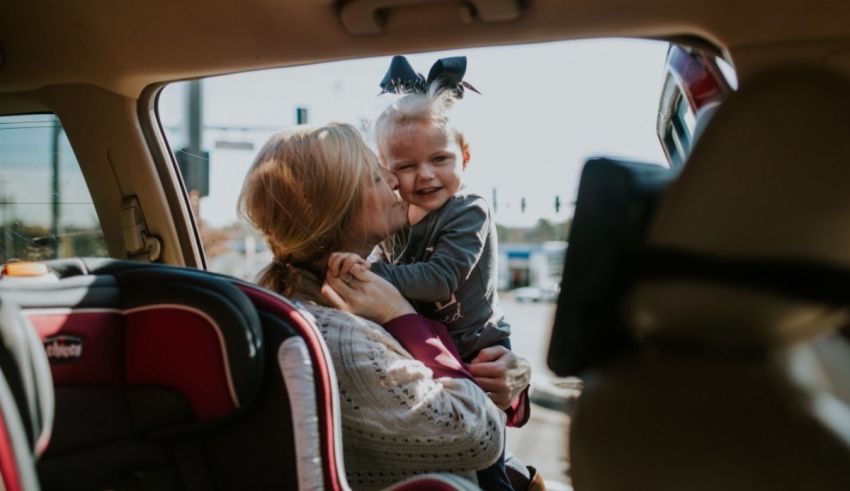 A woman holding a baby in a car.