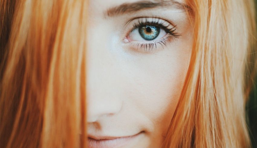 A close up of a woman with red hair and blue eyes.