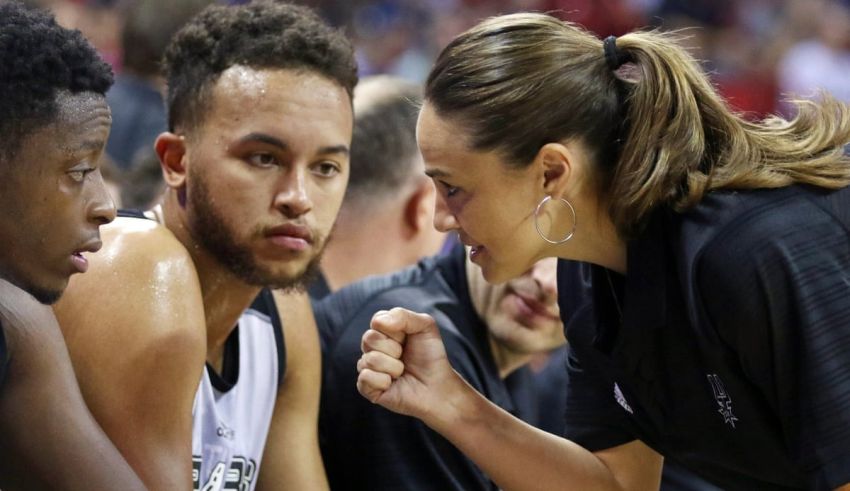 San antonio spurs coach mike taylor talks to a player during a game.