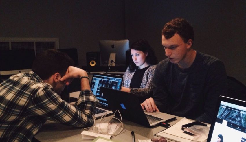 A group of people working on laptops in a recording studio.