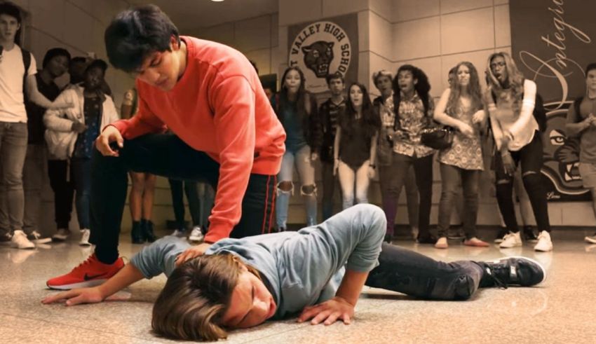 A man laying on the ground in front of a group of people.