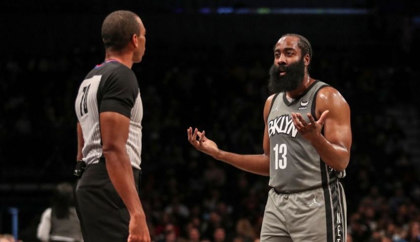 A basketball player is talking to a referee during a game.