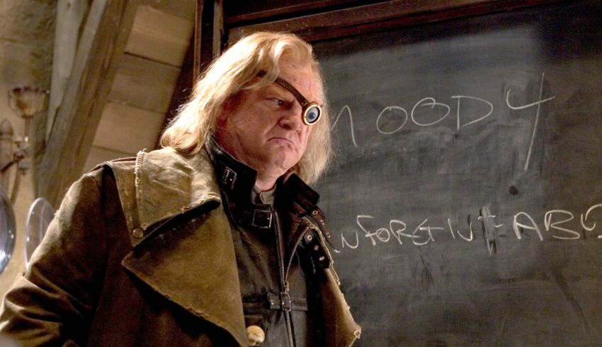 A man in a coat standing in front of a chalkboard.