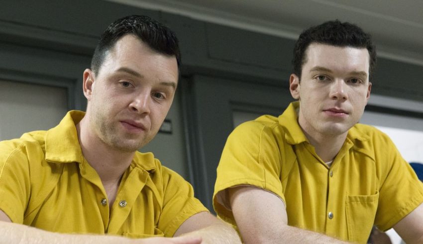 Two men in yellow uniforms sitting at a table.