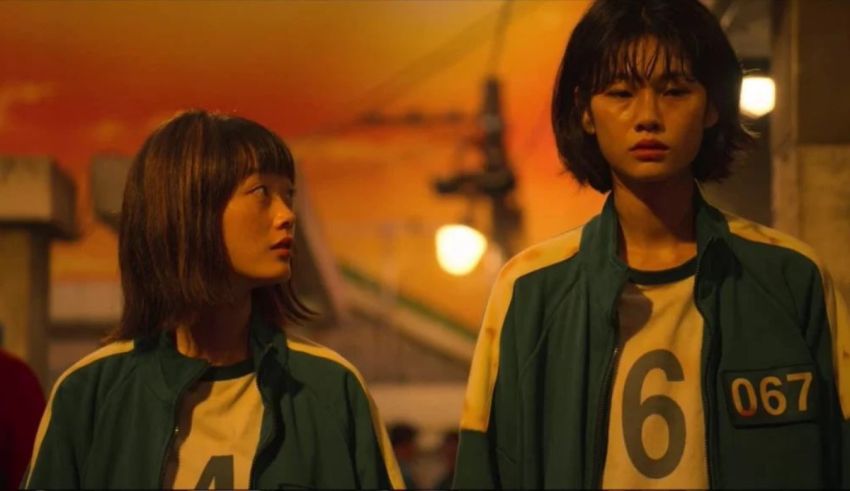 Two asian girls in green uniforms standing next to each other.