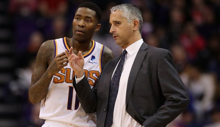 A man in a suit and tie talking to another man.