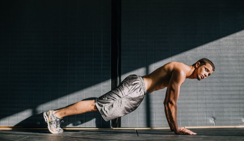 A man is doing push ups in a gym.