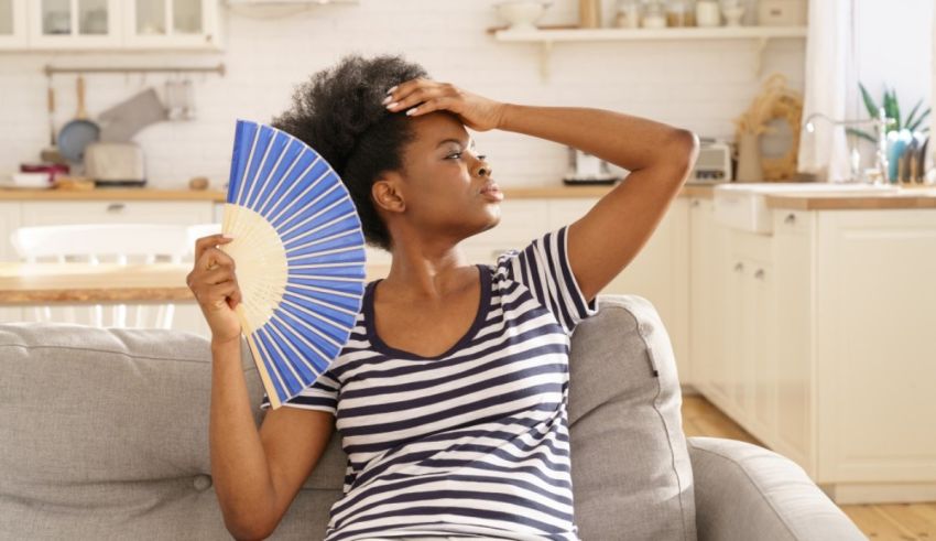 A woman holding a fan in the living room.